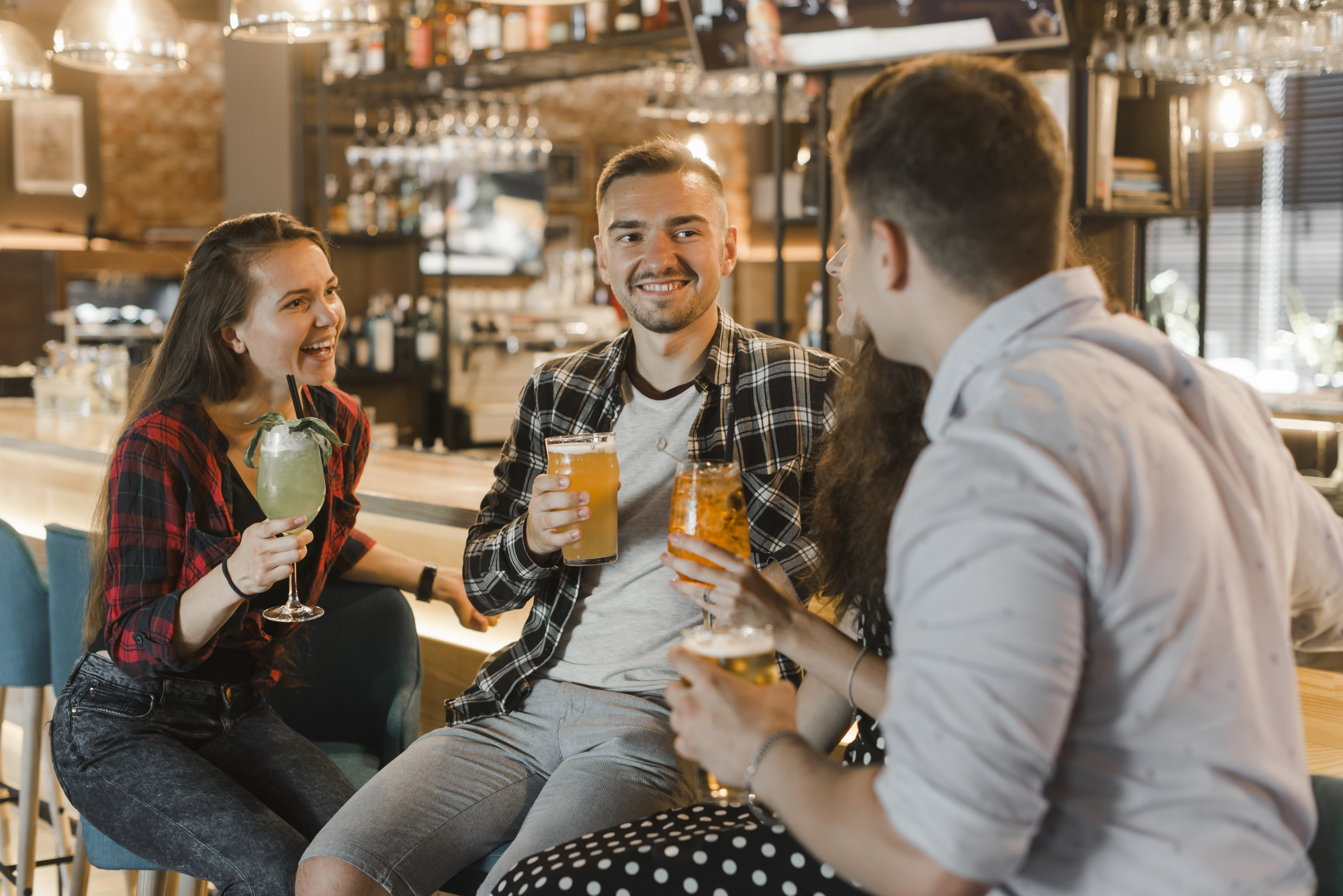 Personen, die mit einem Drink in der Hand zusammensitzen und lachen